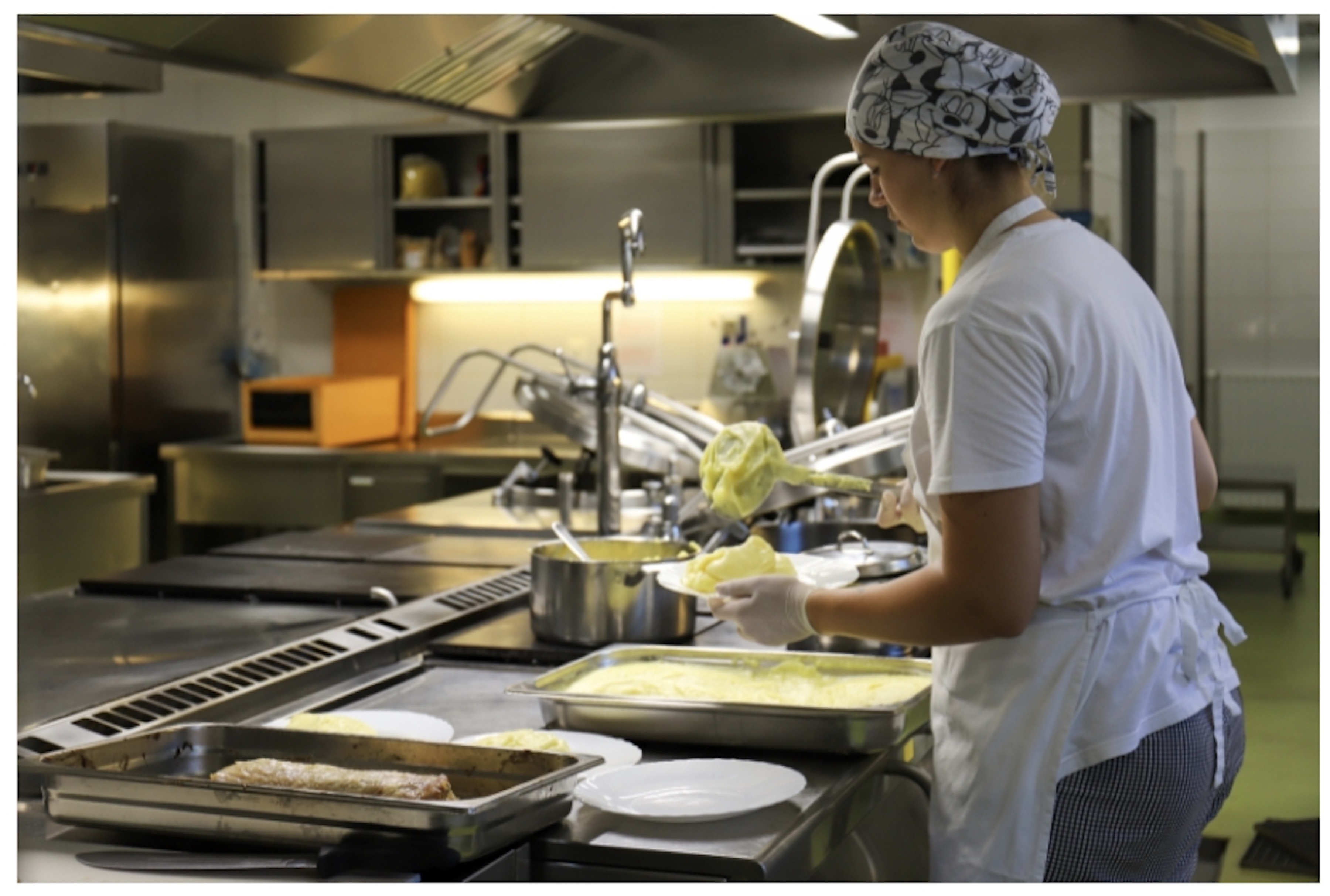 Kuhar v šolski kuhinji pripravlja obrok